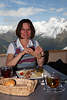 Adler Lounge Frau vor Speisen in Wolkenhhe mit Panoramablick auf Alpengipfel