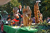 Kunsthandwerker mit Holzsge zeigt geschnitzte Holzfiguren Foto auf Erntefestwagen in Steinbeck