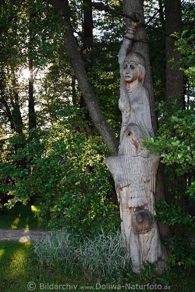 Galindia slawische Kriegerin Holzskulptur im Baum vor Sonne Masurens im Freilichtmuseum Mrchenwald am Beldahnsee
