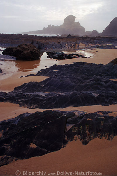 Schwarze Felsen an Ponta Ruiva im Sand an Atlantik Westkste unweit Torre de Aspa & Vila do Bispo