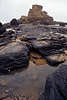 9124_ Schwarze dunkle dicke Felsbrocken Granitfelsen Foto an Ponta Ruiva Atlantik Westkste wildem Felsenstrand in Wasser liegen