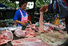 Thaimarkt in Bangkok, Thai Verkuferin & Kufer am Marktstand mit Fleisch, Schweinefleisch