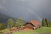 Almhaus Skischule Ossi Bild unter Regenbogen Stimmungsfoto in Sonne nach Gewitter ber Alpental Urlaub Reisetip