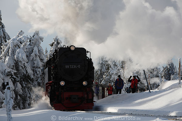 Harz-Bahnlok in Schnee Winterbild unter Dampf Menschen neben schwarzer Lokomotive