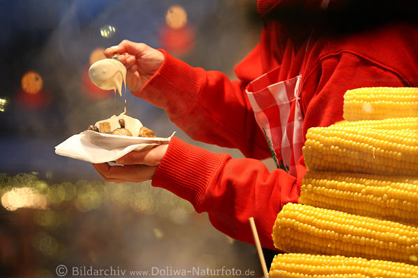 Advent-Essen in Kerzenlicht heie Champignons in Hnden Dampf gelbe Maiskolben Weihnachtsmarkt Romantik