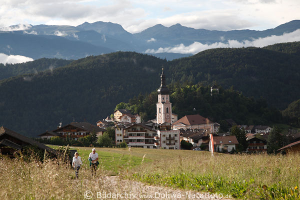 Wandererpaar auf Fusspfad vor Kastelruth Stadthuser in Sdtirol weiten Landschaft Panorama