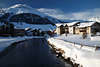 901126_ Celerina Huser am Fluss Foto unterm Berg in Winter, Oberengadin Alpen romantische Landschaft